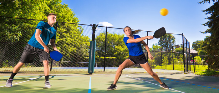 a man and woman playing pickleball